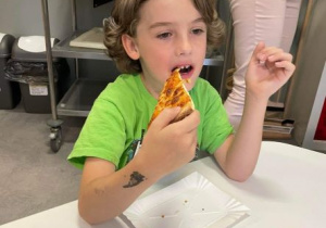 Chłopiec je pizzę